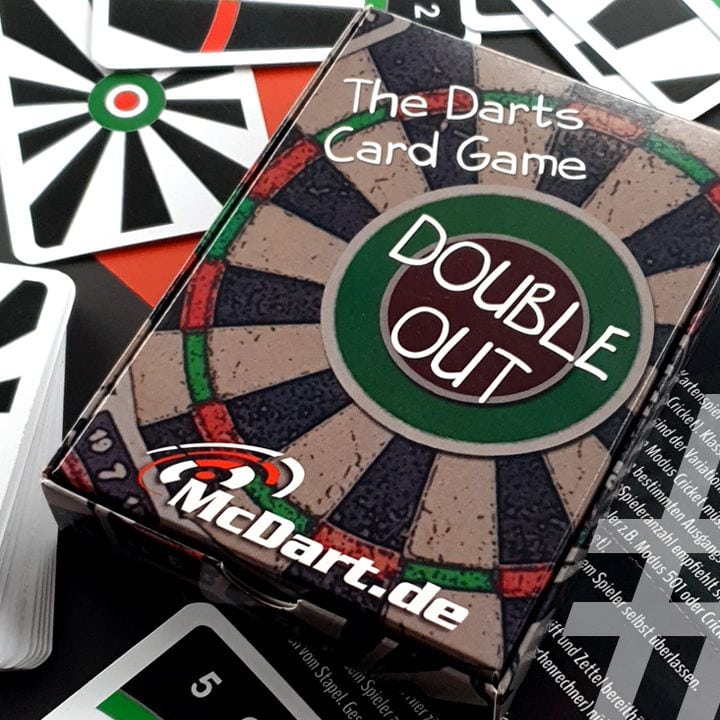 DoubleOut Das Bild zeigt ein Kartenspiel mit dem Namen "Double Out – The Darts Card Game". Die Spielschachtel liegt auf verschiedenen Spielkarten, die an eine Dartscheibe erinnern.