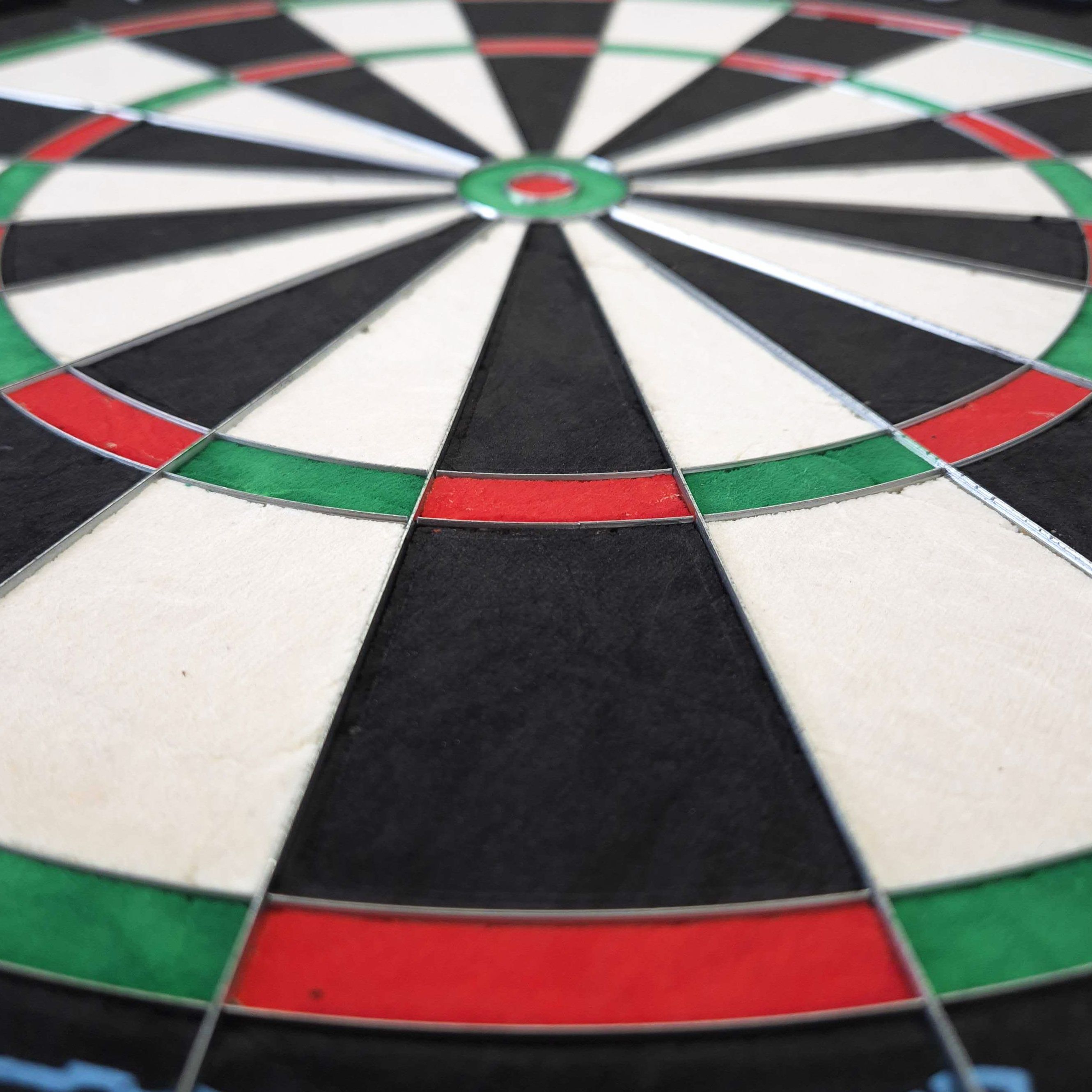 Bersaglio per freccette in acciaio Mission Samurai Infinity Das Bild zeigt eine Nahaufnahme eines Steeldartboards mit klar erkennbaren Farbfeldern in Rot, Grün, Schwarz und Weiß. Es handelt sich um das Produkt "Mission Samurai Infinity Steeldartboard".