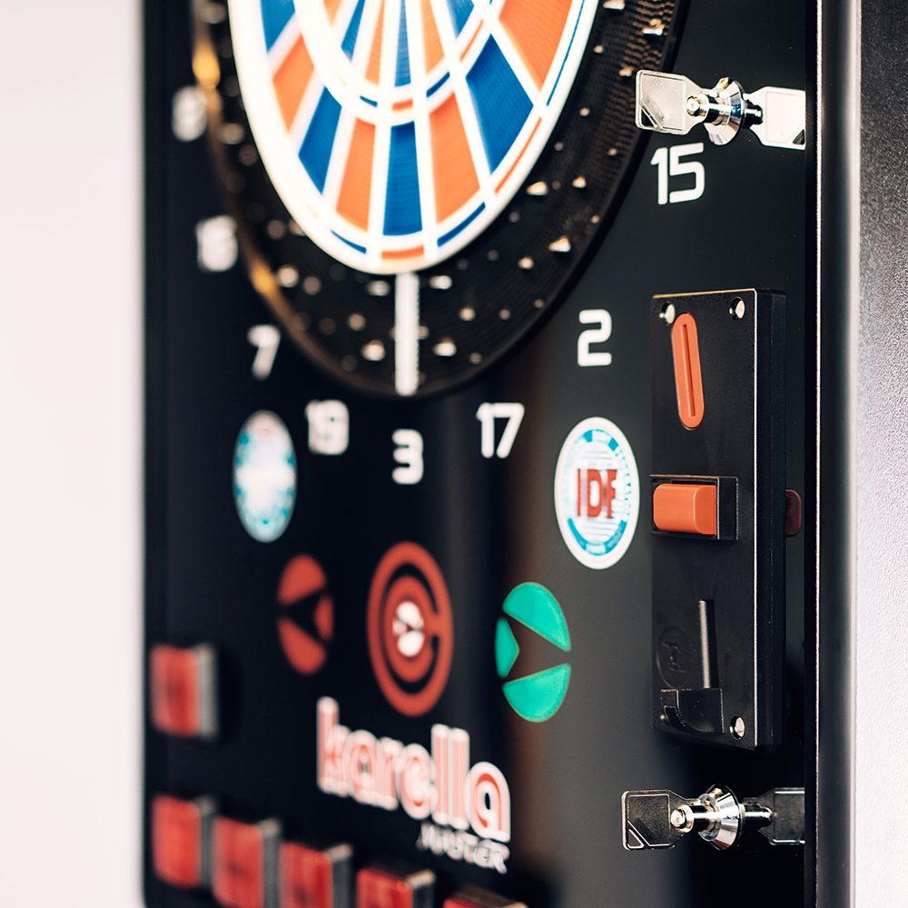 Karella_E-Master_Dartautomat_Detail_Mit_M-nzeinwurf Das Bild zeigt den Karella E-MASTER Dartautomaten mit Münzeinwurf. Man sieht das elektronische Dartboard sowie den Münzeinwurf und verschiedene Bedienelemente.