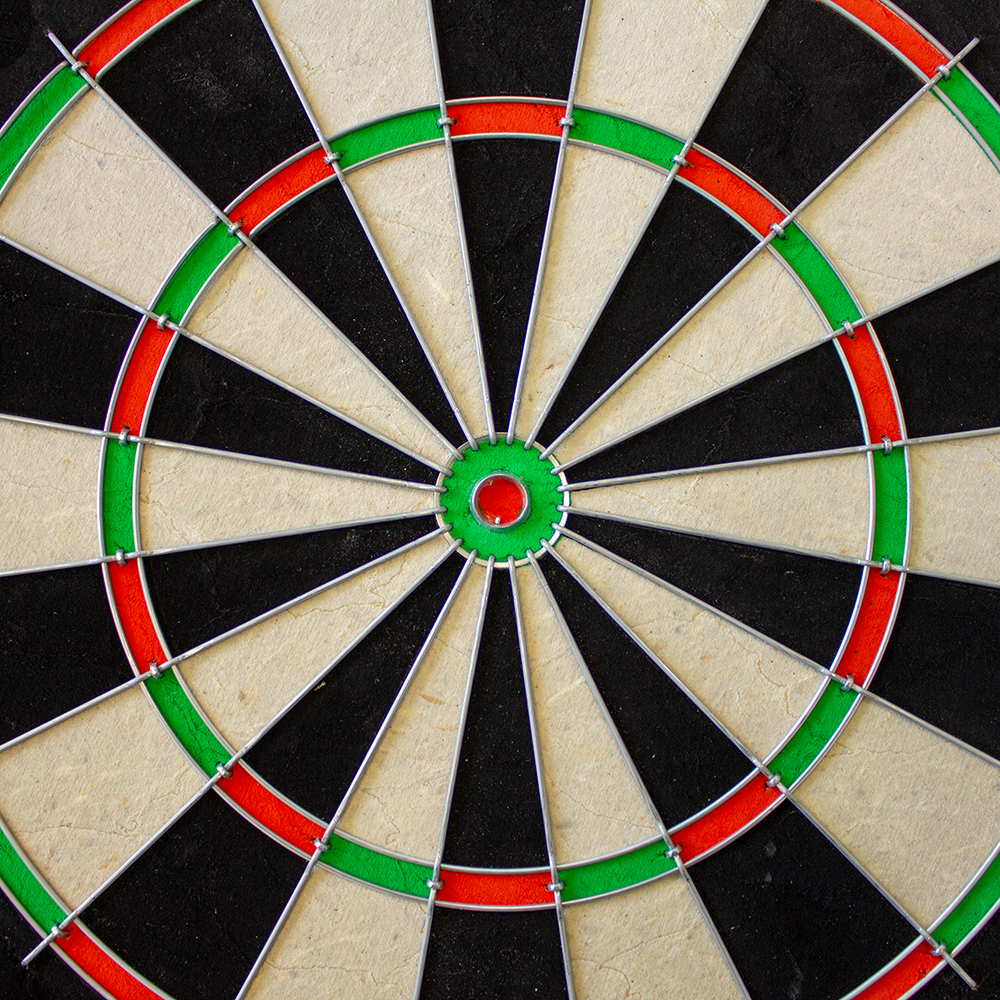 1602_Winmau_Pro_SFB_Dartboard_3 Das Bild zeigt ein Winmau Pro SFB Dartboard aus nächster Nähe. Die Zielscheibe ist in schwarze, weiße, grüne und rote Abschnitte unterteilt.