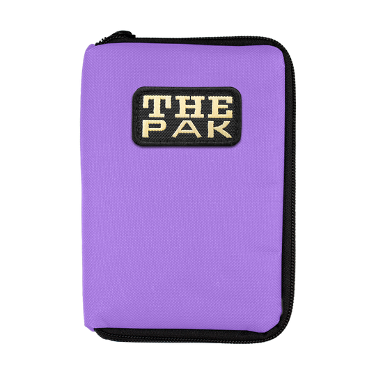 708TP_The_Pak_Dartcase_Violett_1 Das Bild zeigt ein lila Etui mit einem Reißverschluss. Auf der Vorderseite befindet sich ein Aufnäher mit der Aufschrift "THE PAK".