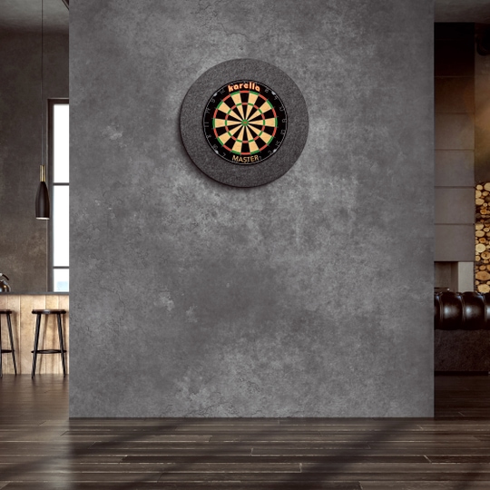 Ocelový rámeček na terč Karella Ultimo An der Wand hängt ein "Karella Ultimo Steeldartboard Surround". Der Raum wirkt modern und stilvoll mit dunklen Farben und eleganter Einrichtung.