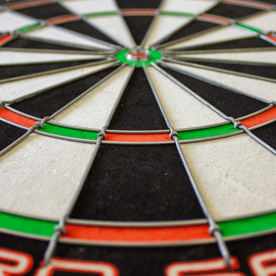 1602_Winmau_Pro_SFB_Dartboard_4 Das Bild zeigt ein Winmau Pro SFB Dartboard aus der Nähe. Die Felder sind klar in Schwarz, Weiß, Rot und Grün unterteilt und von Metalldrähten abgegrenzt.