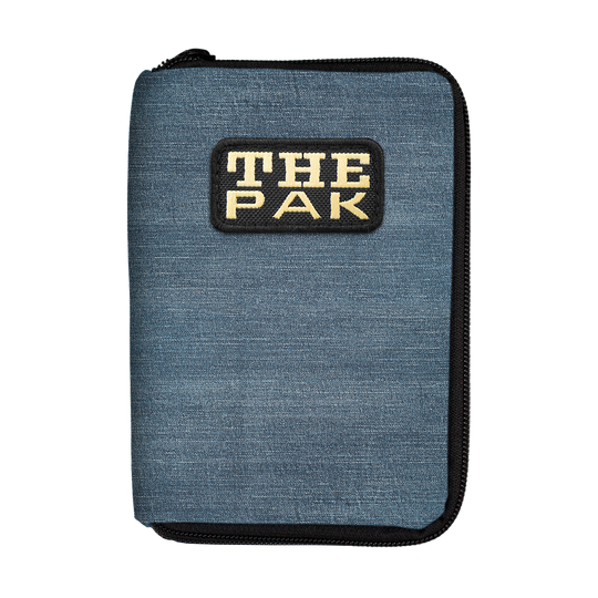 715TP_The_PAK_Jeans_Editon_Darttasche_1 Die Abbildung zeigt das Produkt "The Pak Jeans Edition Darttasche". Die Tasche ist blau und hat vorne ein auffälliges "THE PAK"-Logo.