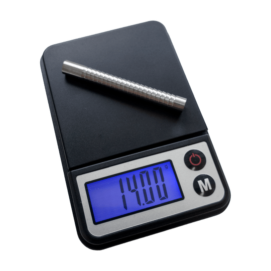 MCD19_McDart_Mini_Waage_1 Die Abbildung zeigt die McDart Mini Waage mit einem Metallstab darauf. Auf dem Display wird ein Gewicht von 14,00 Gramm angezeigt.