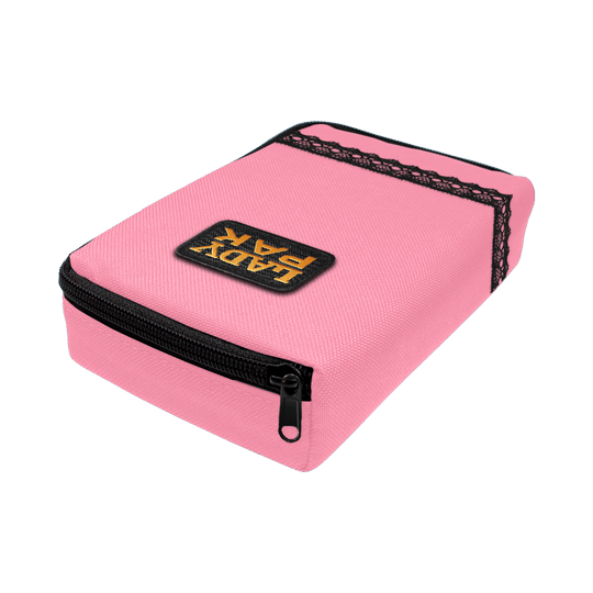 713TP_The_Pak_Dartcase_LadyPak_Rosa_2 Das Bild zeigt ein pinkfarbenes Etui namens "The Pak Dartcase - Lady Pak" mit einem schwarzen Reißverschluss. Auf dem Etui ist ein Patch mit der Aufschrift "LADY PAK" angebracht und es ist mit schwarzer Spitze verziert.