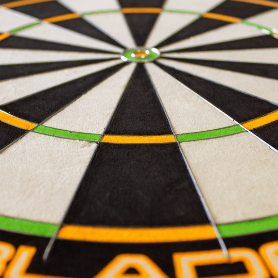 3023_Winmau_Champions_Choice_DualCore_Dartboard_41u5LXrxYR12sE Das Bild zeigt eine Nahaufnahme eines Winmau Champions Choice DualCore Dartboards. Deutlich zu sehen sind die farbigen Segmente und scharfen Abtrennungen auf der Dartscheibe.