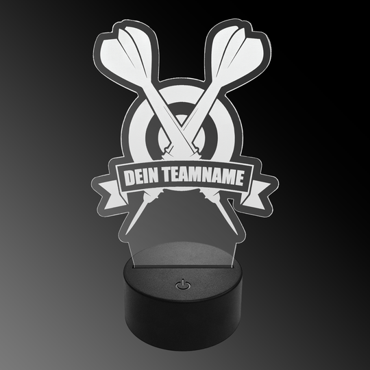 LED plexiglass dart lamp with custom text Das Bild zeigt eine LED-Lampe aus Plexiglas in Form von zwei gekreuzten Dartpfeilen vor einer Zielscheibe. Auf einem Banner steht der Text "DEIN TEAMNAME".