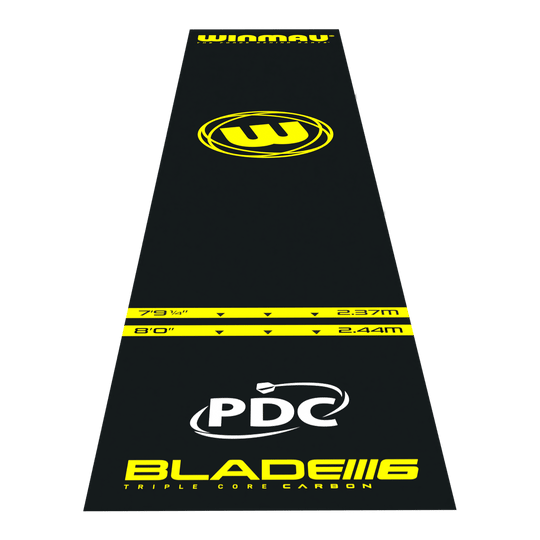 Tappetino per freccette in PVC Winmau Pro-Zone Essential Das Bild zeigt die Winmau Pro-Zone Essential PVC Dartmatte in schwarzer Farbe mit gelben Markierungen. Auf der Matte sind verschiedene Entfernungsmarkierungen, das Winmau-Logo sowie die Aufschrift "BLADE 6" und "PDC" zu sehen.